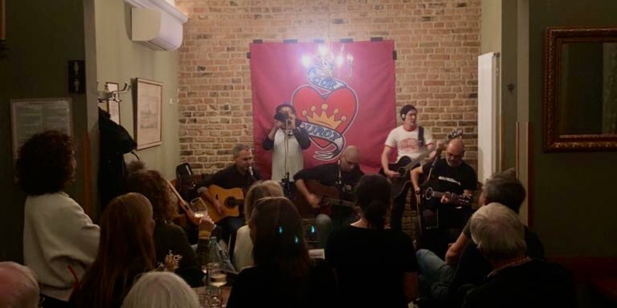 Corduroy im Glauburg Cafe, hinten die Band vor einer Backsteinwand, beleuchted von einem Kronleuchter, vorne Publikum von hinten gesehen durch den Raum