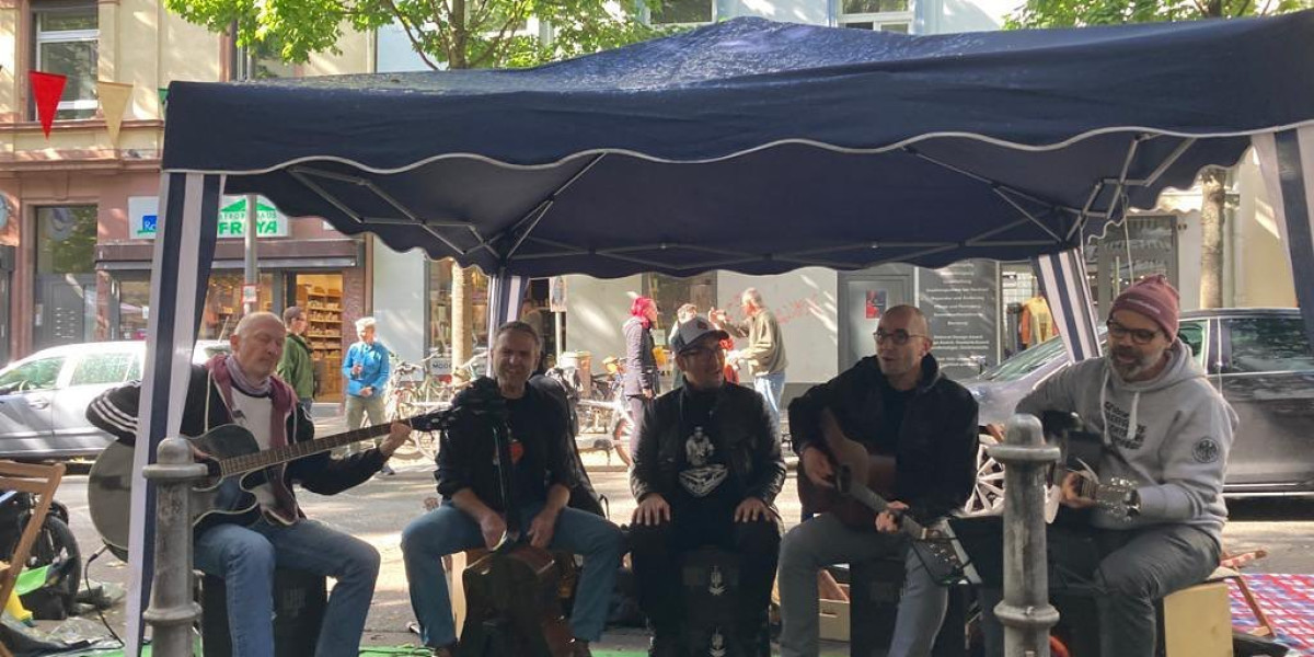 Die Jungs sitzen unter einem Pavilon und machen Musik